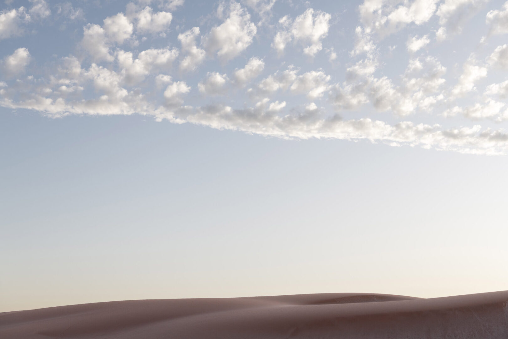 A desert landscape with clouds in the sky.